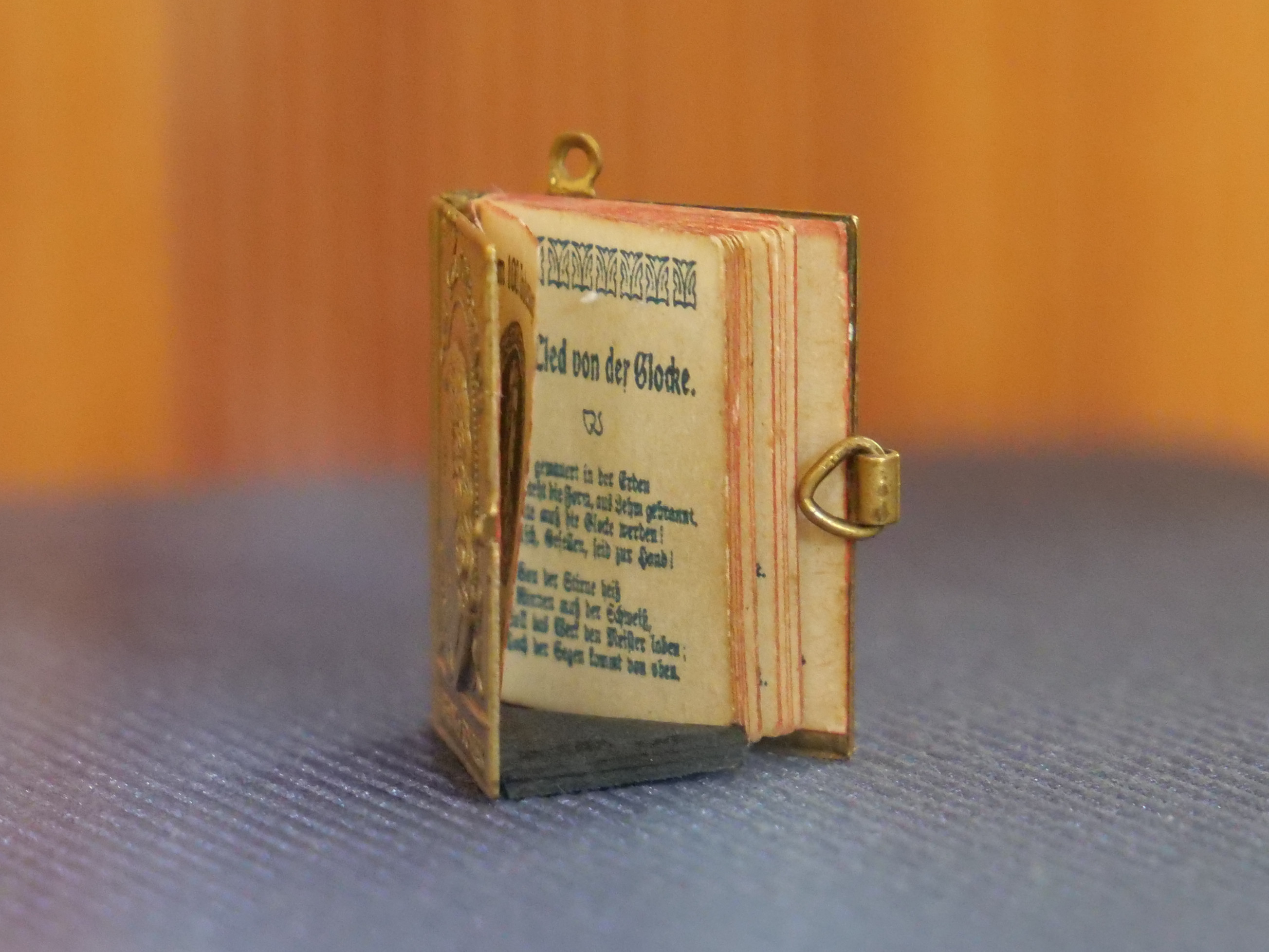 KI generiert: Das Bild zeigt ein Porträt eines Mannes mit lockigem, blondem Haar, der nachdenklich dreinschaut und seinen Kopf auf eine Hand stützt. Er trägt einen dunklen Anzug mit weißem, rüschenverziertem Hemd.